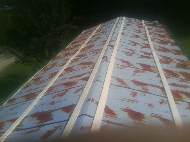 Rusted metal roof panels with new wood purlins before replacement — Storm Damage Roof Repair in Footville by Roofing Brothers