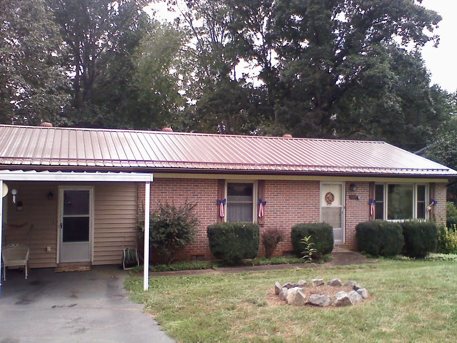 Bronze metal roof and carport on a brick ranch home — Roof Repair work by our crew in Footville